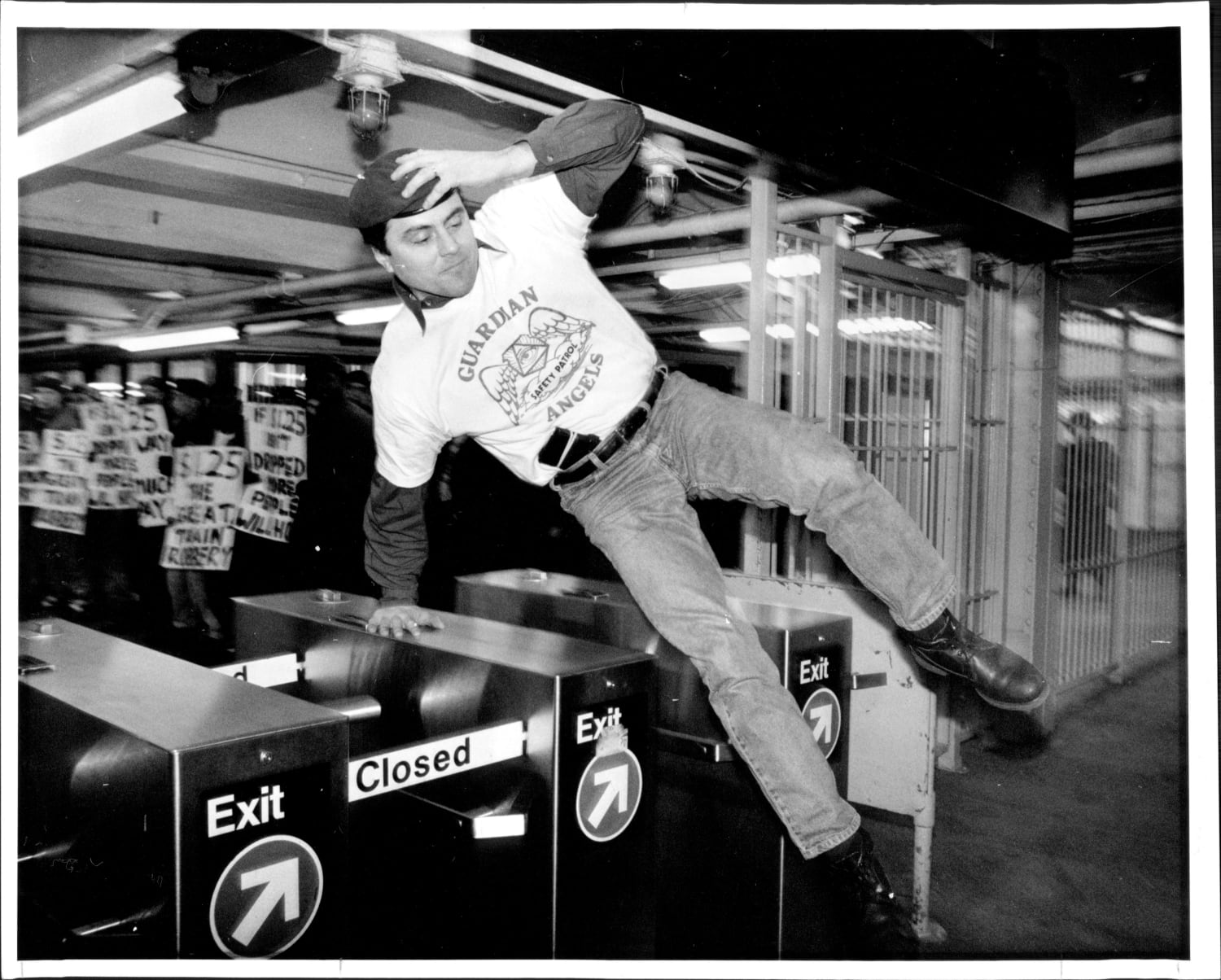 Curtis Sliwa, founder of the Guardian Angels vigilante group, jumps over a turnstile to protest an increase in subway fare (New York City, 1991)