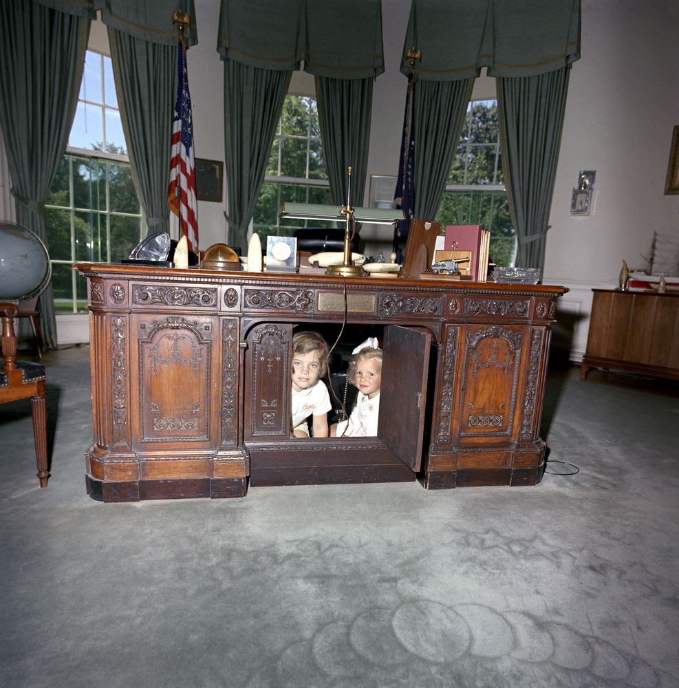 JFK's daughter Caroline and RFK's daughter Kerry play under the Resolute desk in the Oval Office, 1963
