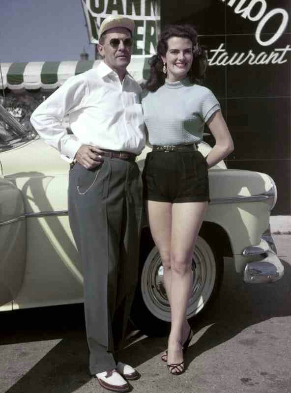 Big shot VIP with a model at a grand opening. Automobile is a 1952 Oldsmobile (?)