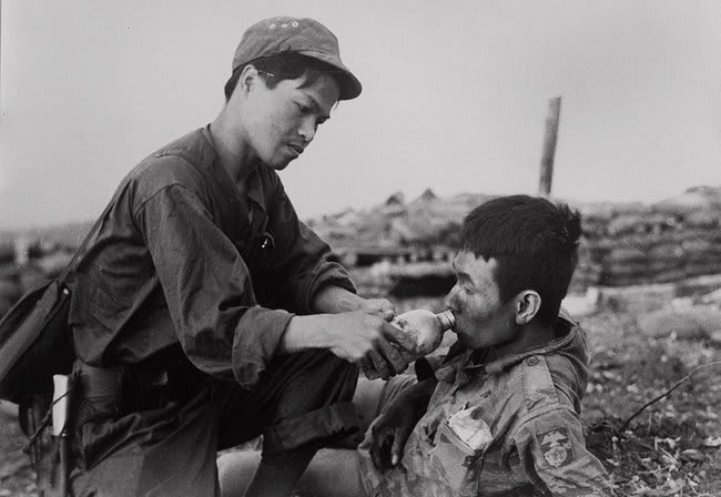 A soldier of the North Vietnamese army letting a marine from the South Vietnamese army drink from his canteen during Operation Lam Son 719. Laos 1971