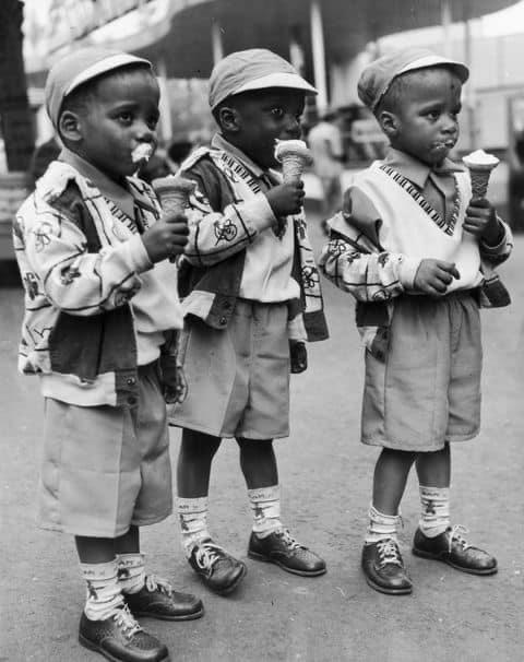 A set of triplets wearing matching outfits dive right into their messy frozen treats, 1965. Hulton Archive/Getty Images
