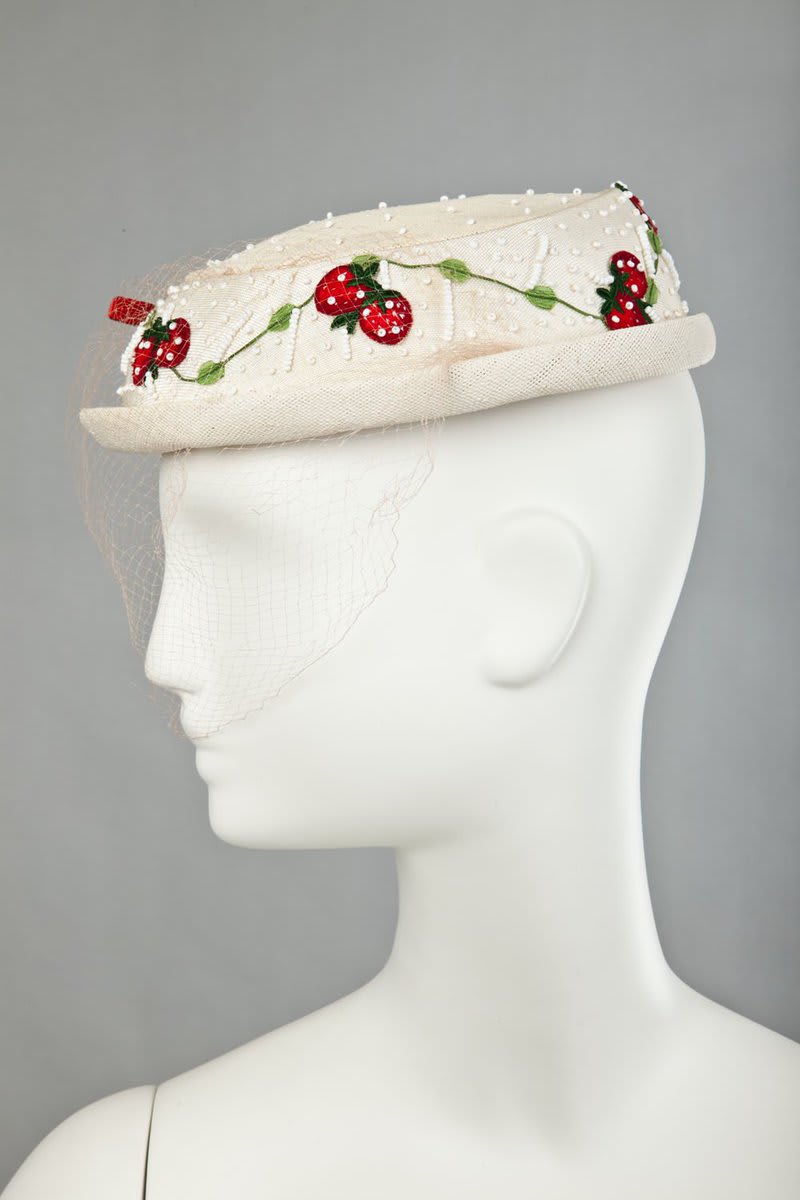 The warmer weather, but one still wants a stylish hat. How about a white hat with a strawberry and vine design? The beads will shine and glitter under light, very charming and attractive! Hat, Elsa Schiaparelli, 1950.