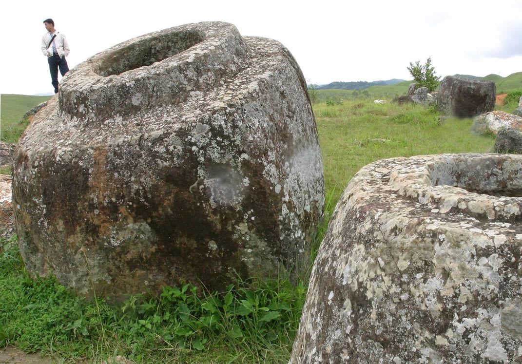 Huge, mysterious 2000-year-old urns in the "Plain of Jars" (Laos). Locals believe they were used by giants and not much research is put into it. They got bombed severely by US planes during Vietnam War, but survived mostly. There are craters and undetonated bombs found in the area today.