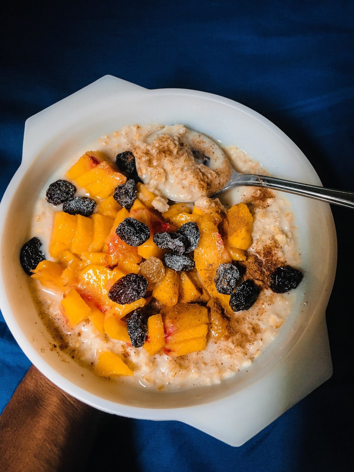 Oatmeal cooked with soy milk, nutmeg & cinnamon, topped off with raisins and a peach. sooo good. You guys have got to try this one out
