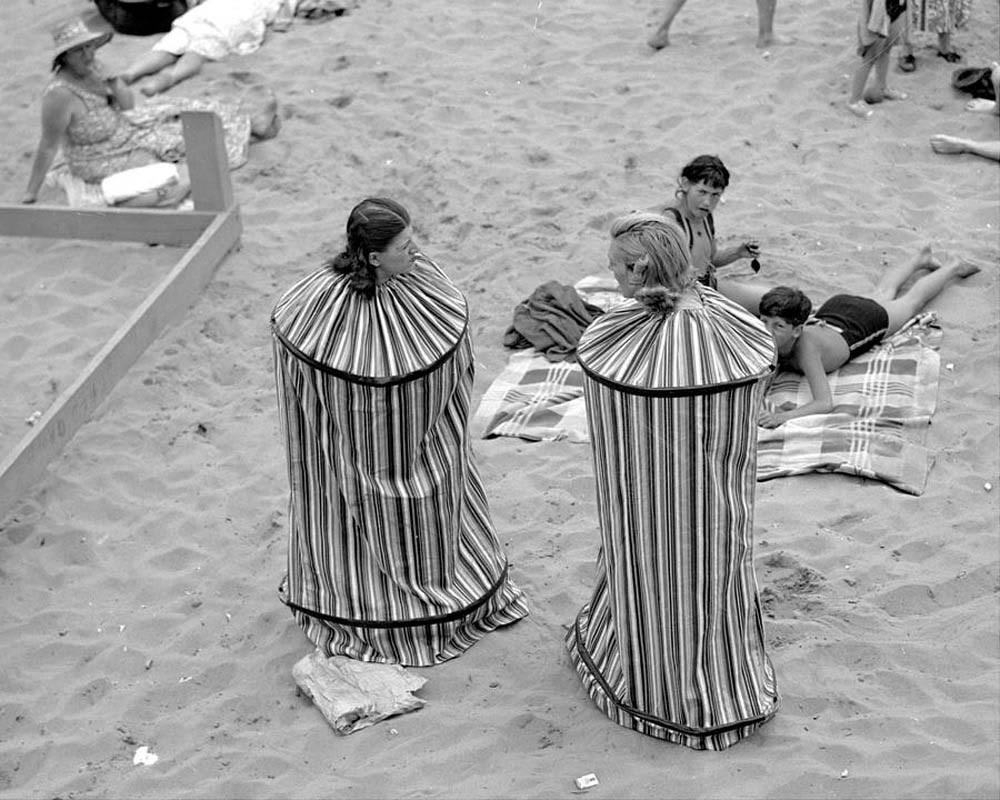 July 4, 1938: Rita Perchetti and Gloria Rossi trying out their new portable bathhouse. They can now change their clothes after sunbathing without having to leave the Coney Island beach.