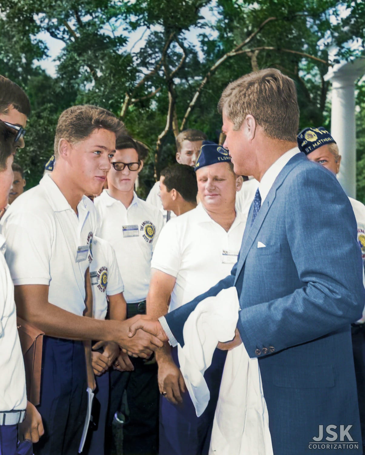 Future president Bill Clinton, a teenage boy, shakes the hand of President John F. Kennedy as other American Legion Boys Nation delegates look on during a trip to the White House in Washington in 1963. Photo by Arnold Sachs [Colorized]