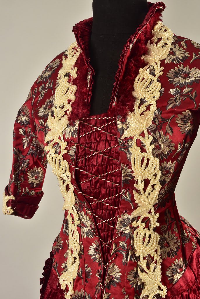 A gown that has it all- an exquisite floral brocade, pearl beaded appliqués, lace trim, and of course, plenty of shirring. Via Whitaker Auctions.