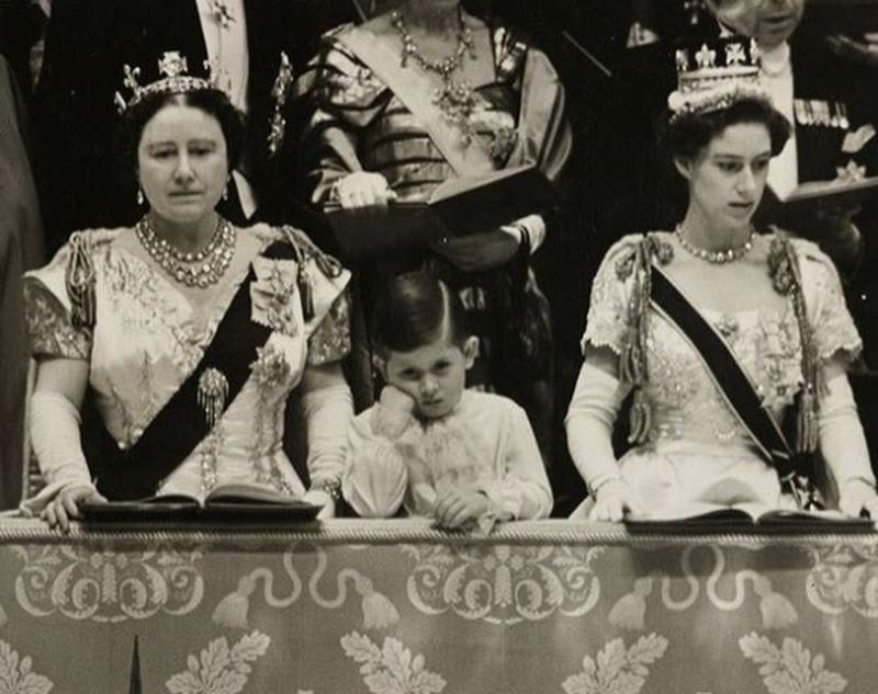 A young Prince Charles standing between his grandmother, The Queen Mother, and aunt, Princess Margaret, at his mother Queen Elizabeth's coronation in 1953